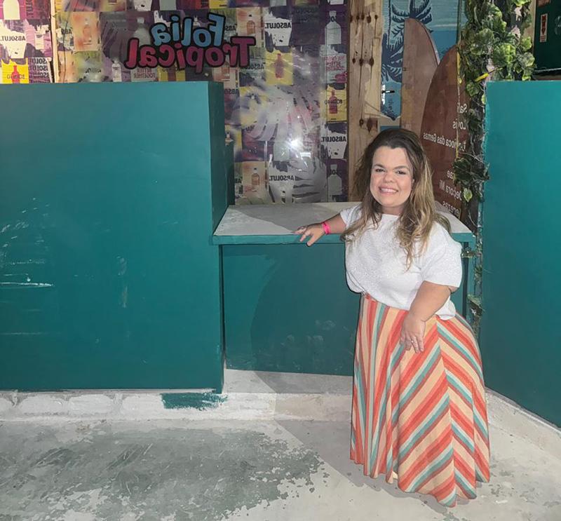 Rebeca Costa standing in front of a lowered bar counter constructed for Carnival